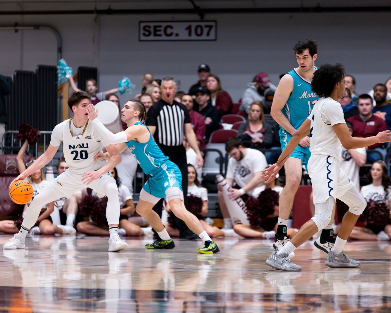 Basketball players from opposing teams compete for possession during intense game action.