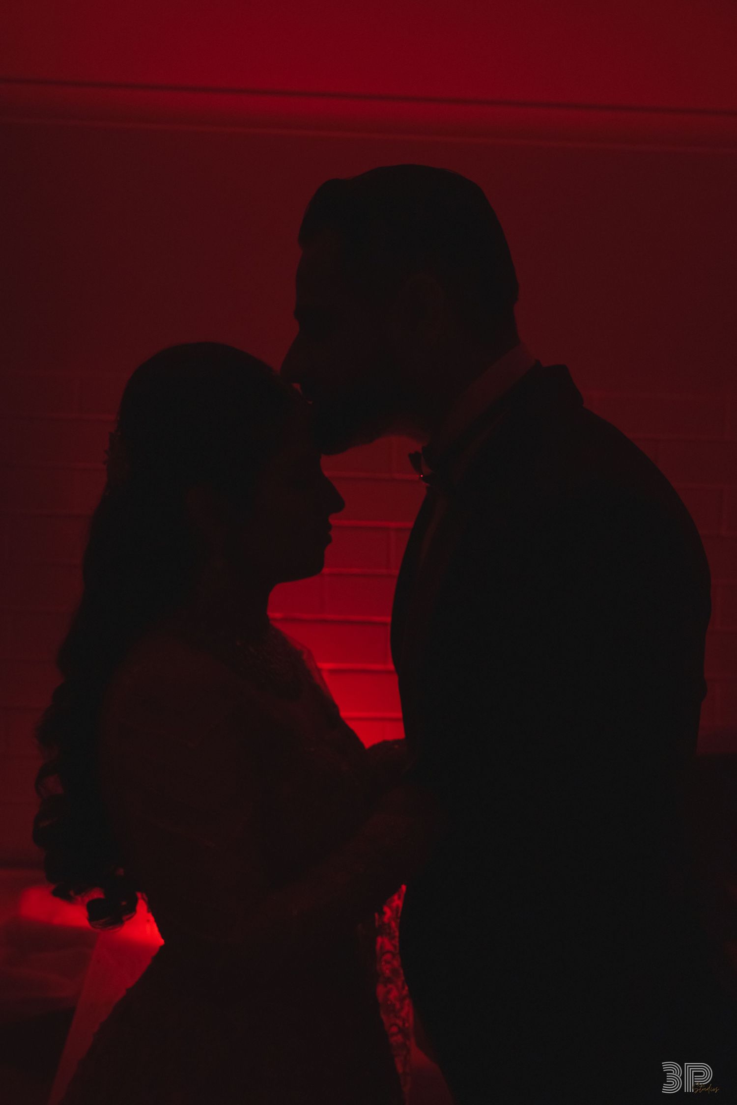 Silhouettes of people dancing in a nightclub with dramatic red lighting and dark shadows.