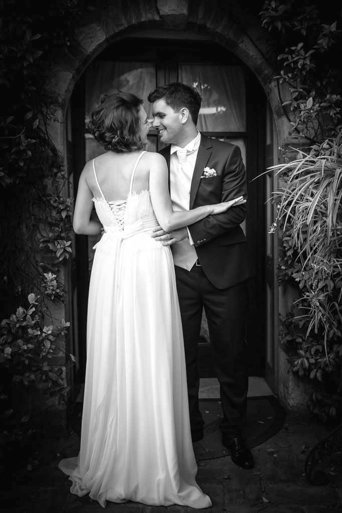 Black and white wedding photo of bride and groom sharing romantic moment in ancient villa in Valpolicella, Verona, Italy