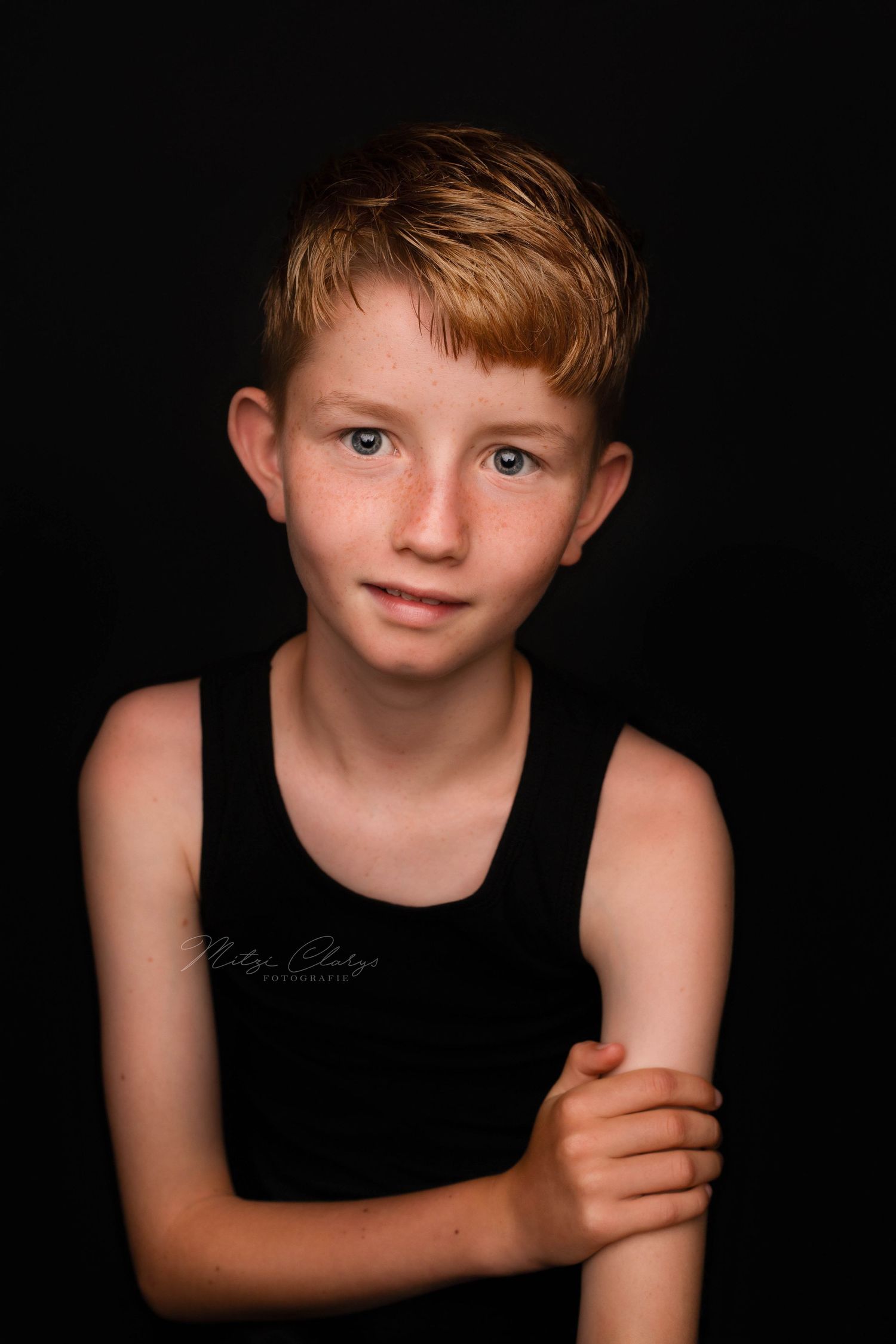 Foto van jongen in zwart shirt met zwarte achtergrond tijdens fotoshoot in Goes