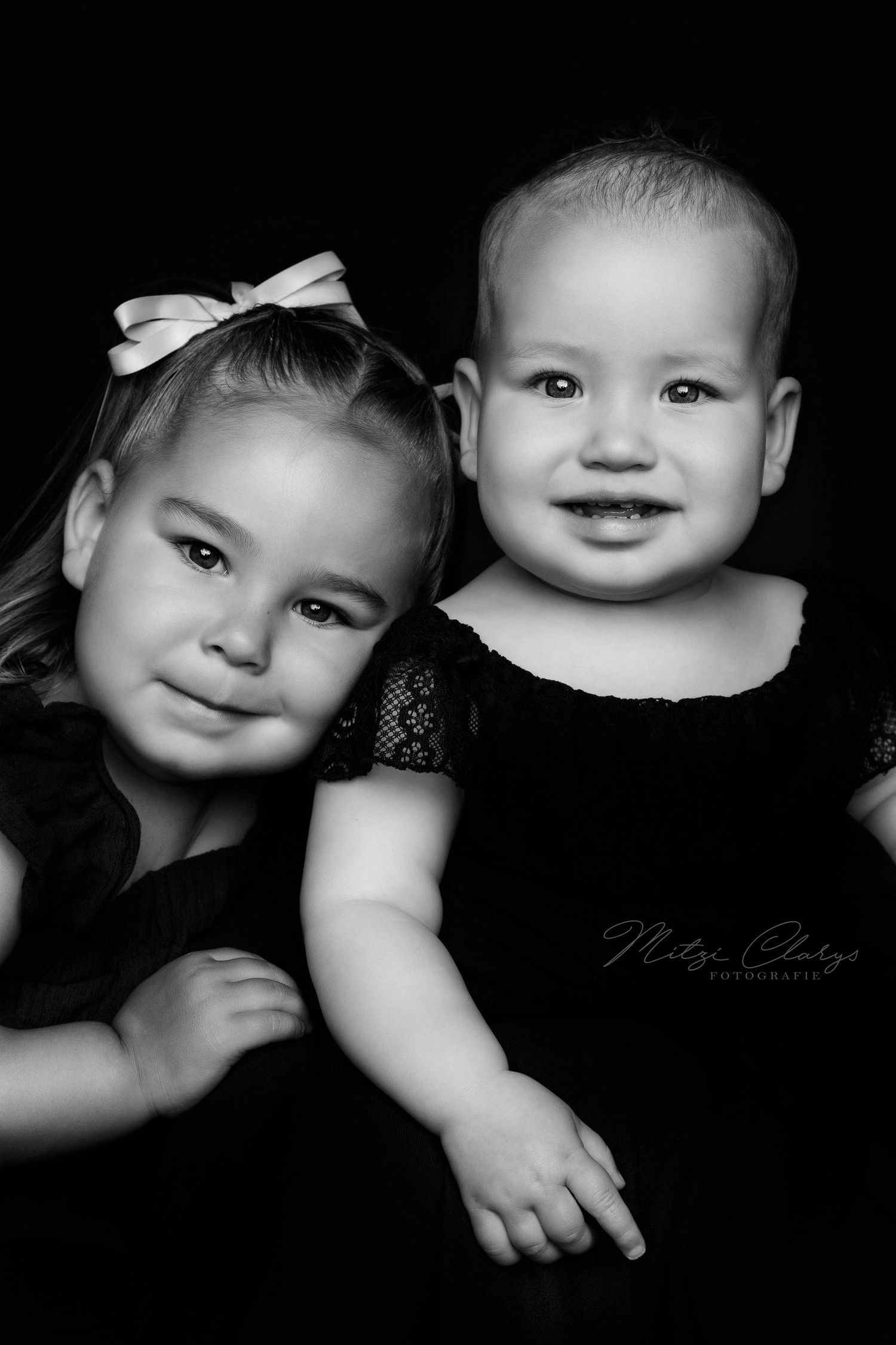 Foto van zusjes, meisje en baby tijdens minishoot met zwarte kleding in Goes