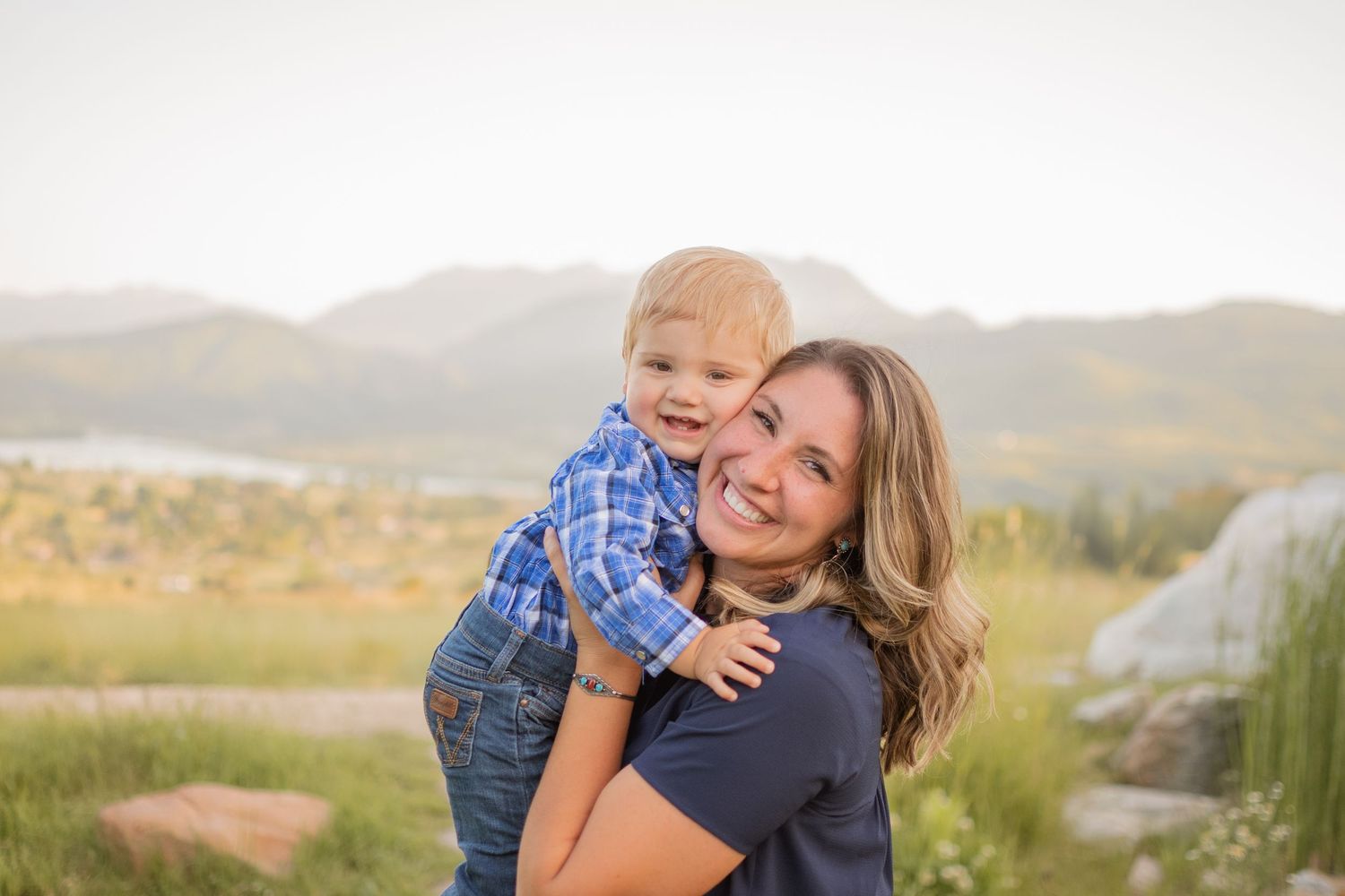 Family photos with little boy hugging mom in mountains