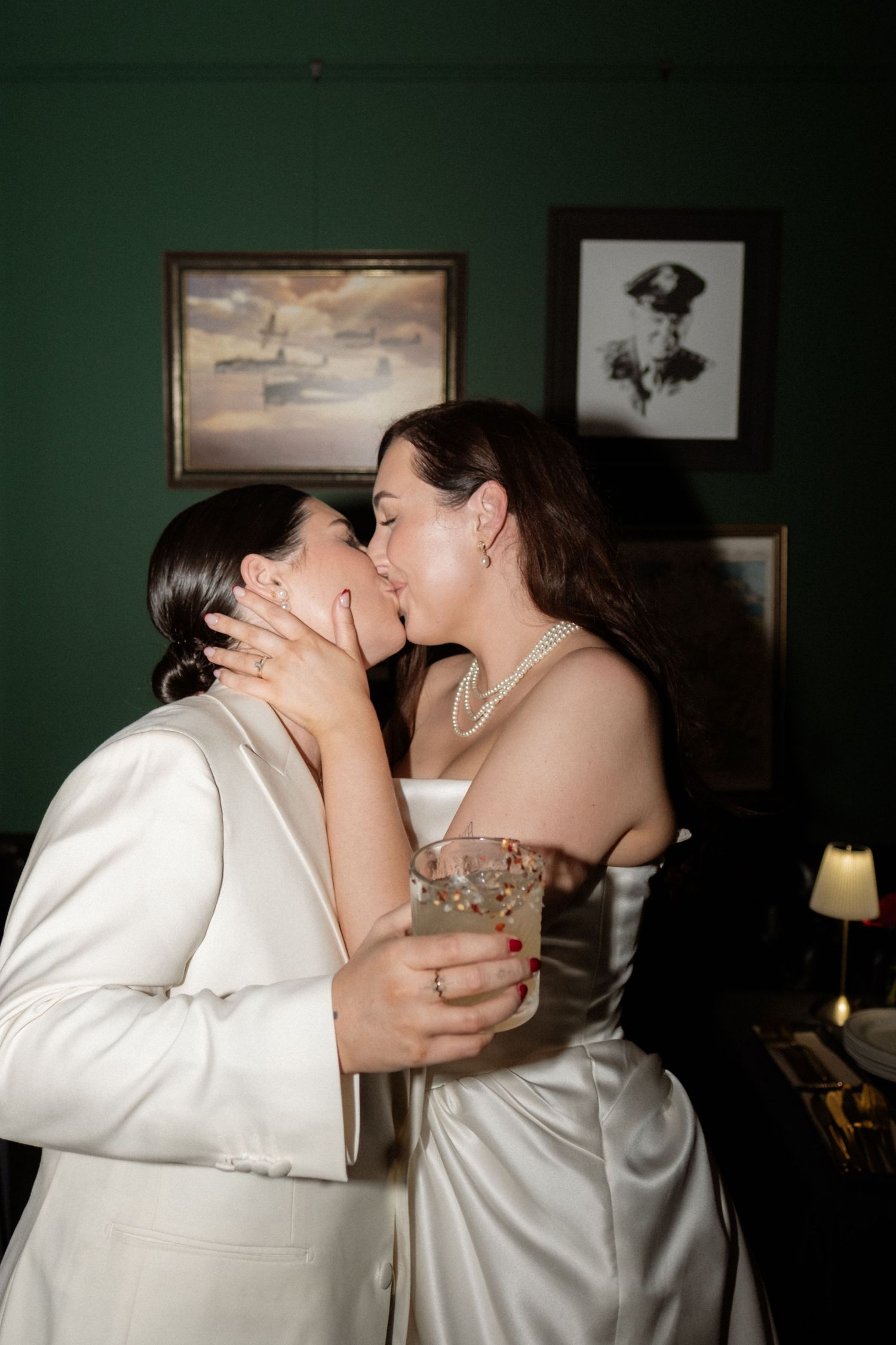 A romantic sequence of four photos showing a couple sharing intimate kisses in a dimly lit room with dark green walls.