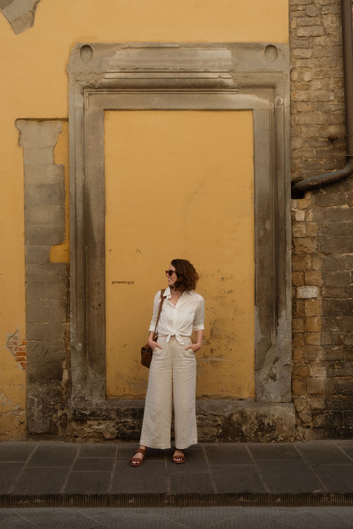 Multiple panels showing a person in white against rustic yellow walls, creating a striking contrast in architectural photography.