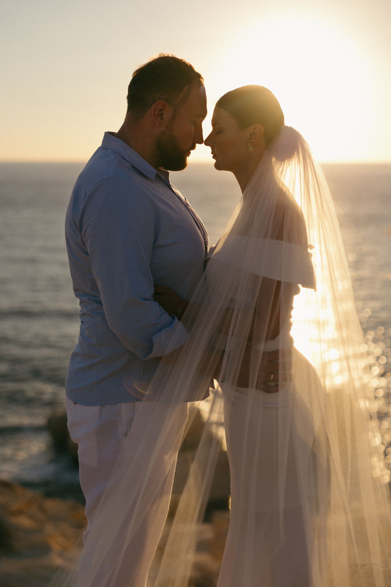 Wedding photographers in Paphos capturing the bride and groom in sunset by the Sea Caves in Cyprus.