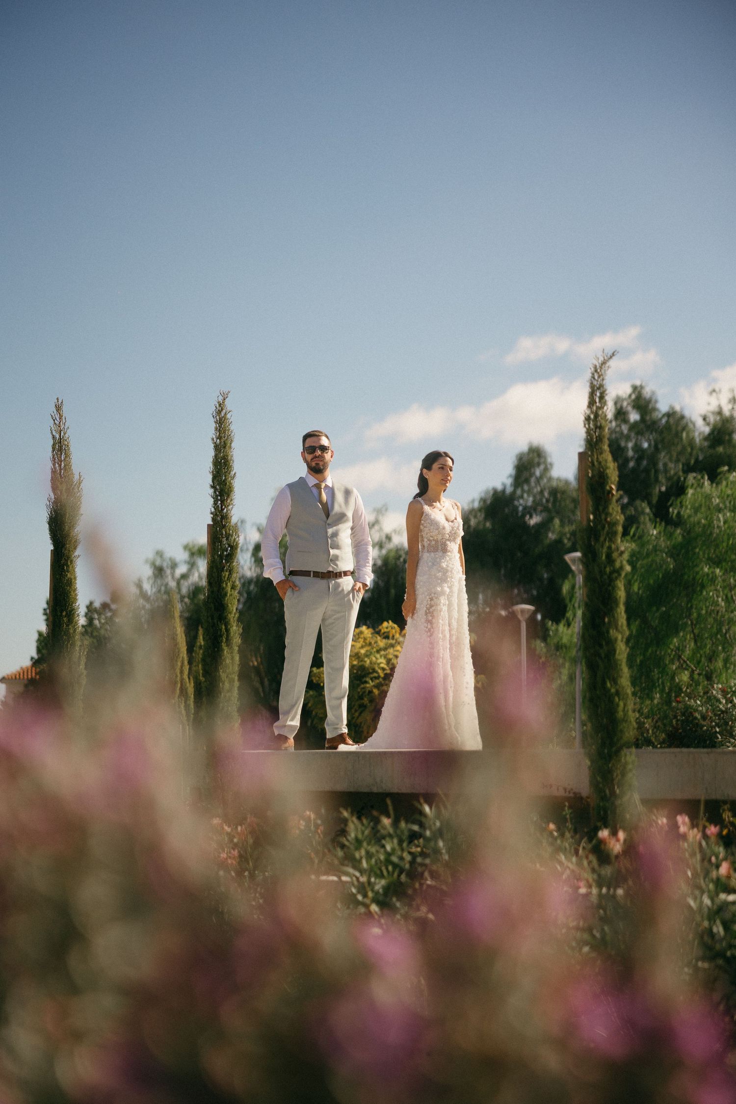 Wedding party standing in a garden creating a dreamy atmosphere in Cyprus captured by a photographer.