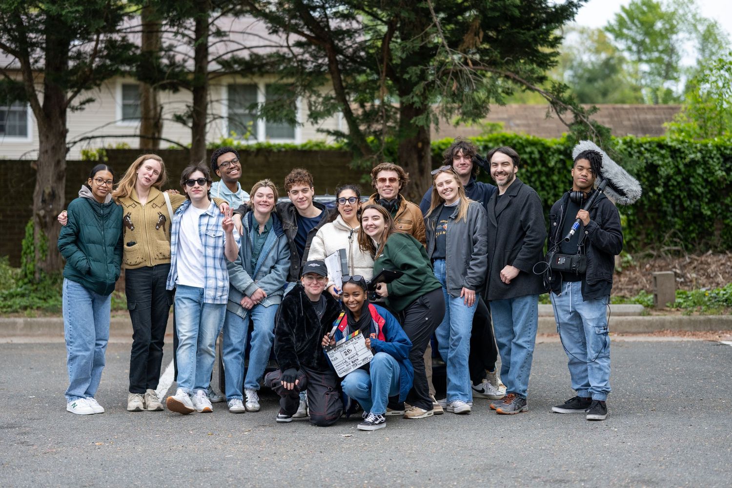 Large group of young people pose together outdoors for casual group photo.