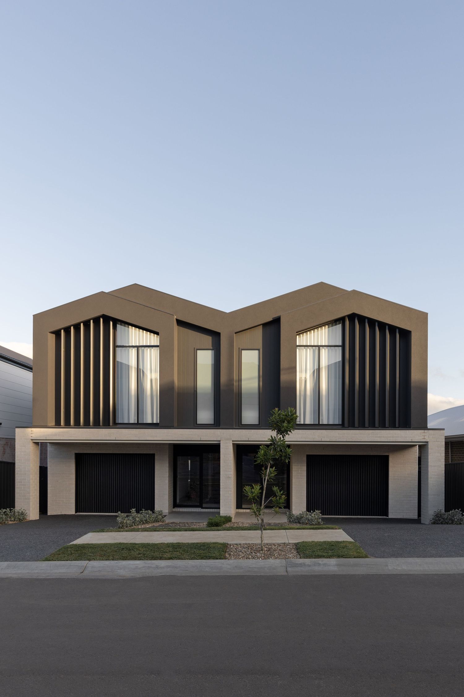 Modern minimalist duplex house with brown exterior and vertical window slats features clean geometric lines and symmetrical design.