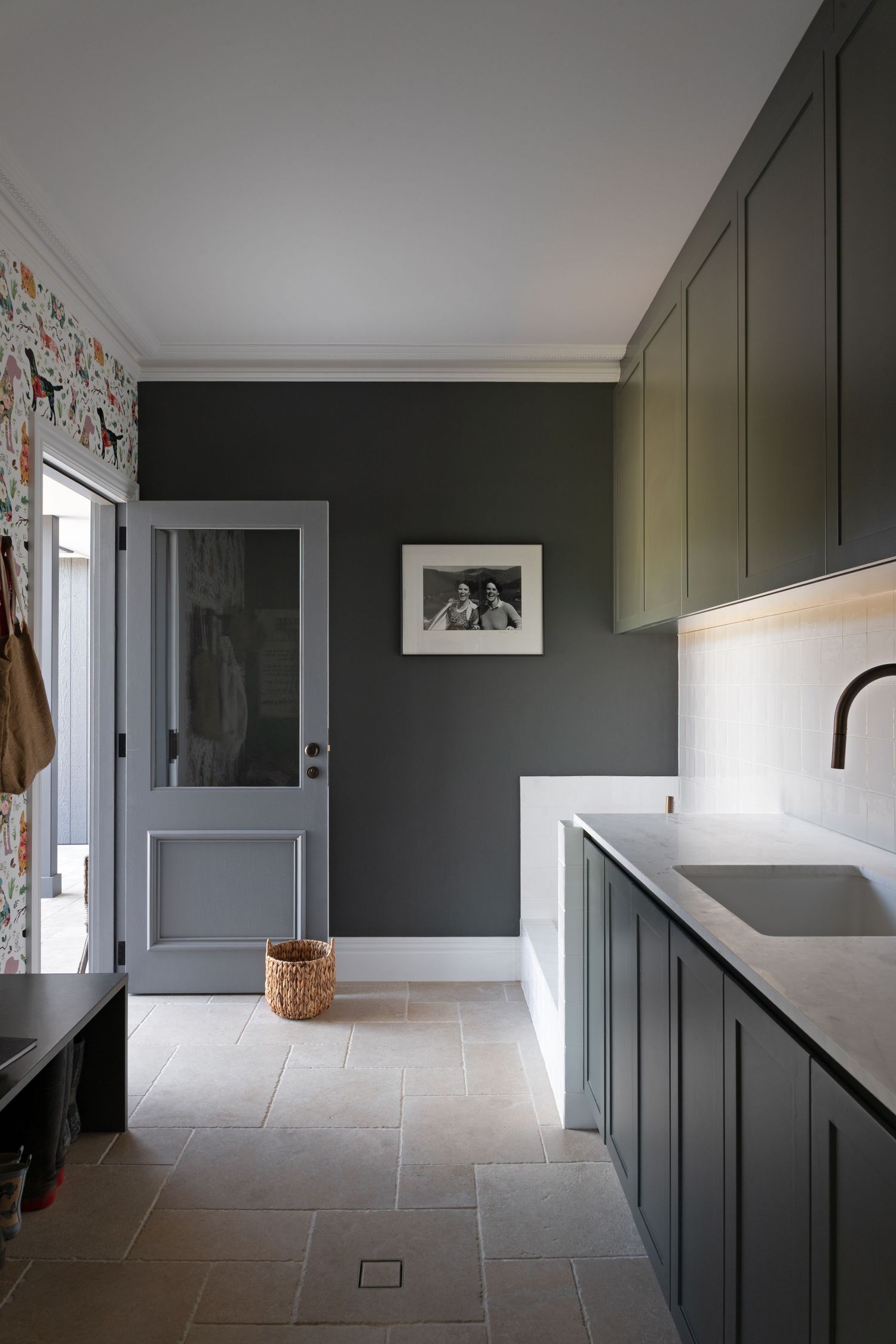 Modern hallway with olive green paneled walls, stone tile flooring, and built-in storage showcases contemporary design.