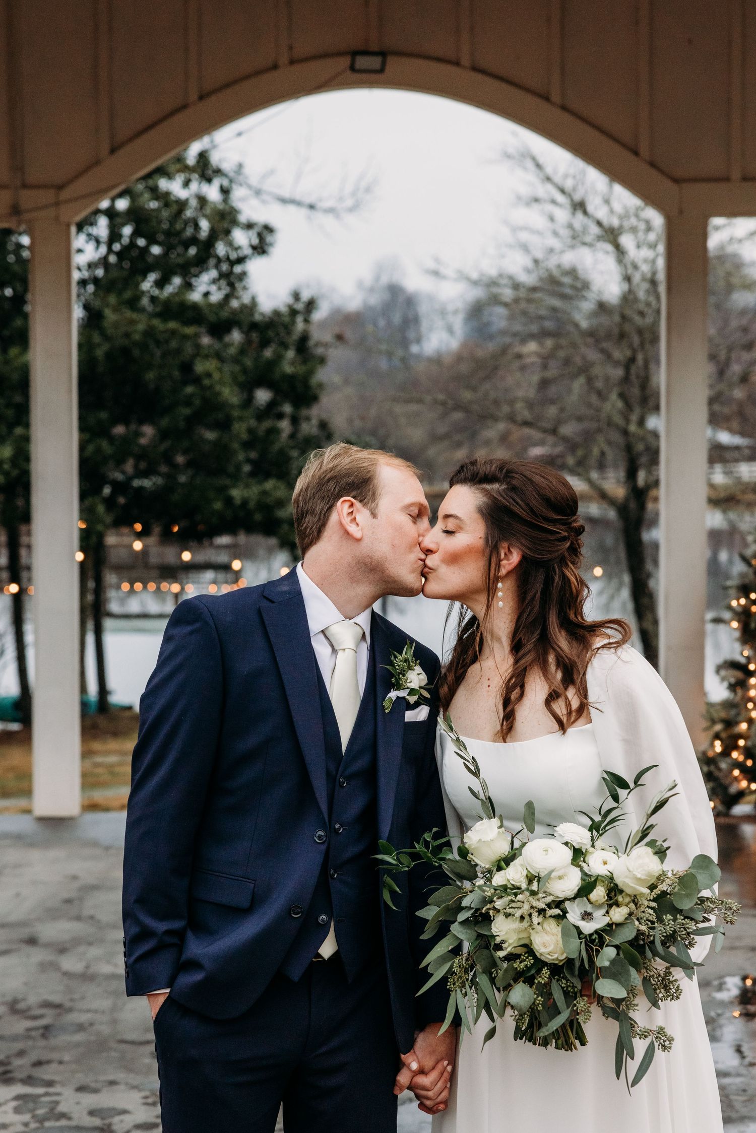 Bride and Groom kissing in front of a lake at a winter wedding in south carolina