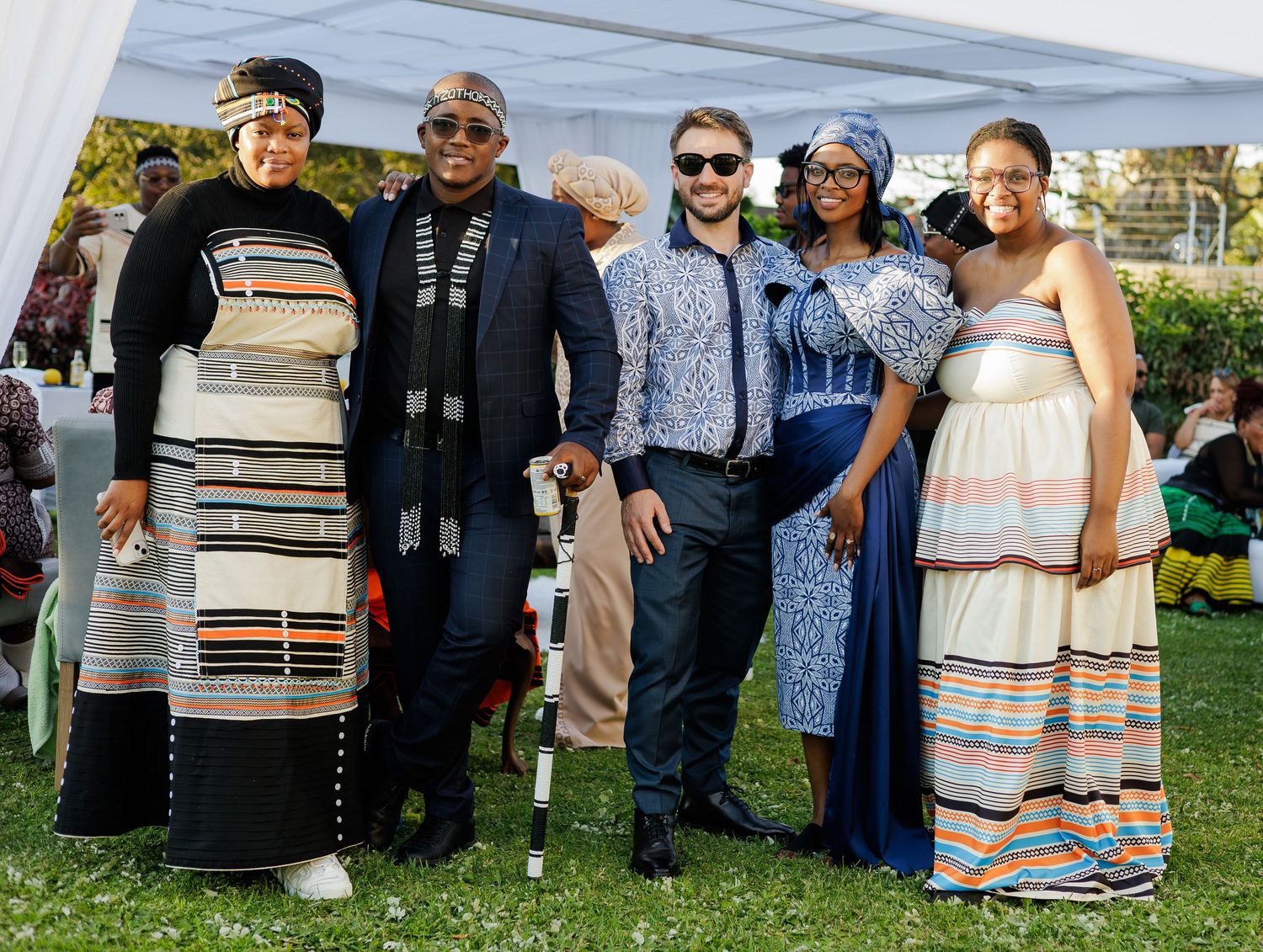 Group of five people in traditional African Xhosa and Ndebele attire posing together at outdoor event.