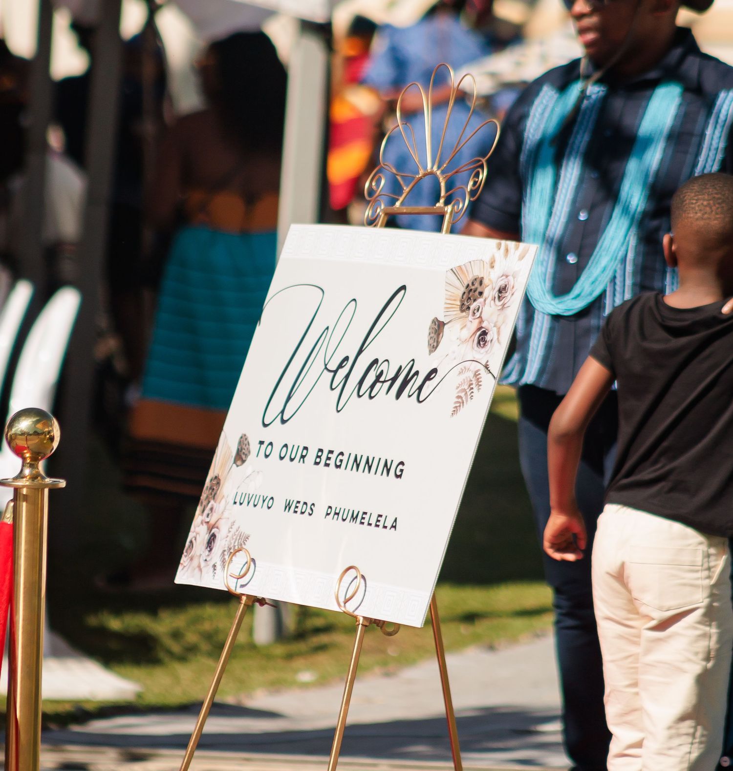 Wedding welcome sign on gold easel reading Welcome To Our Beginning for Luvuyo and Phumelela.
