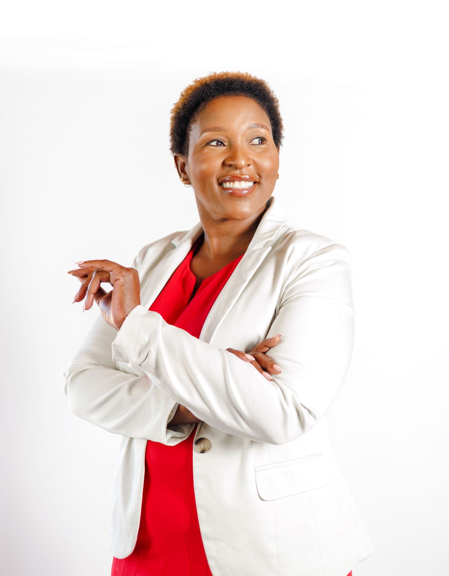 Confident woman in white blazer and red top smiles in professional portrait.