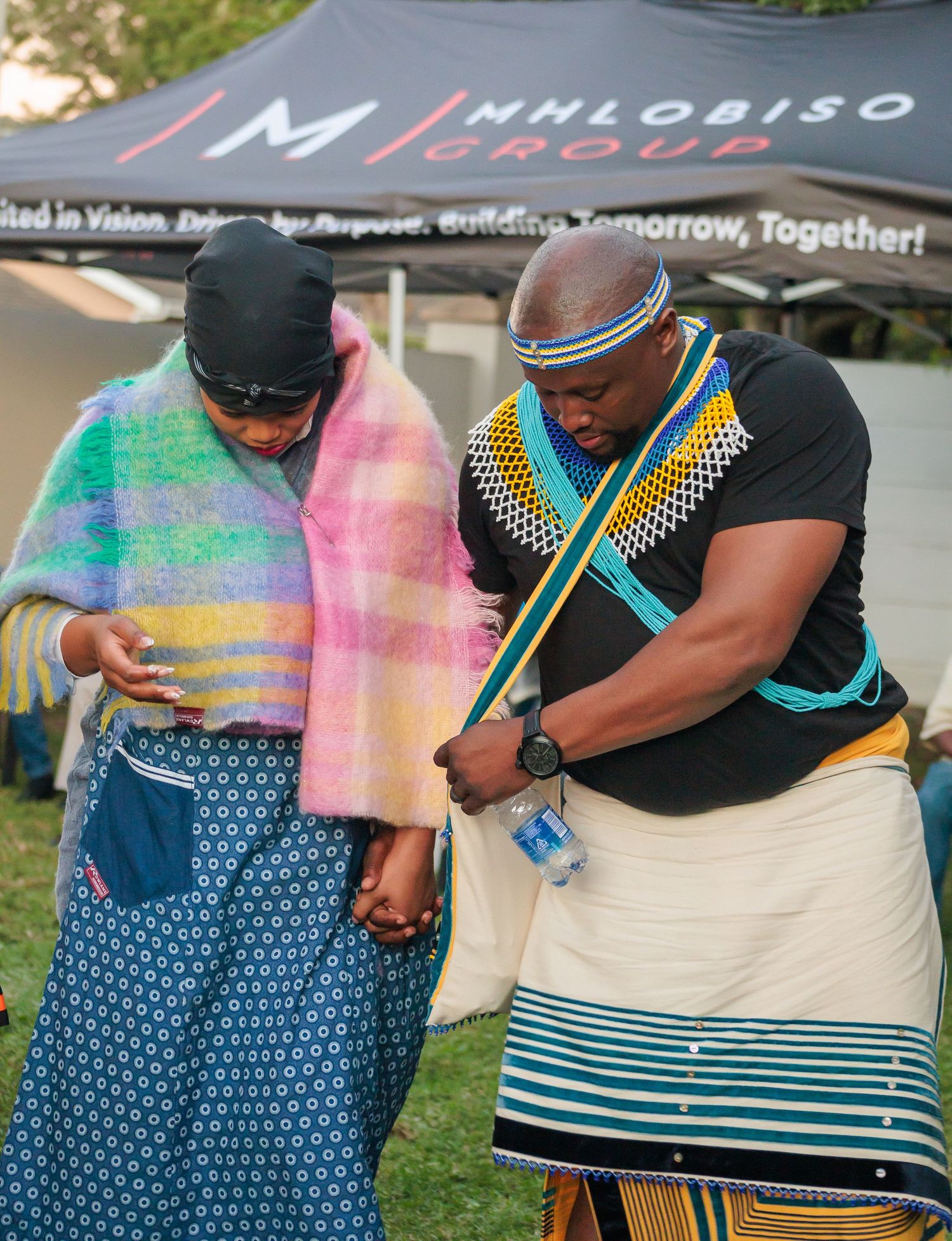 Couple in traditional Zulu beaded attire sharing a moment at an outdoor cultural ceremony.