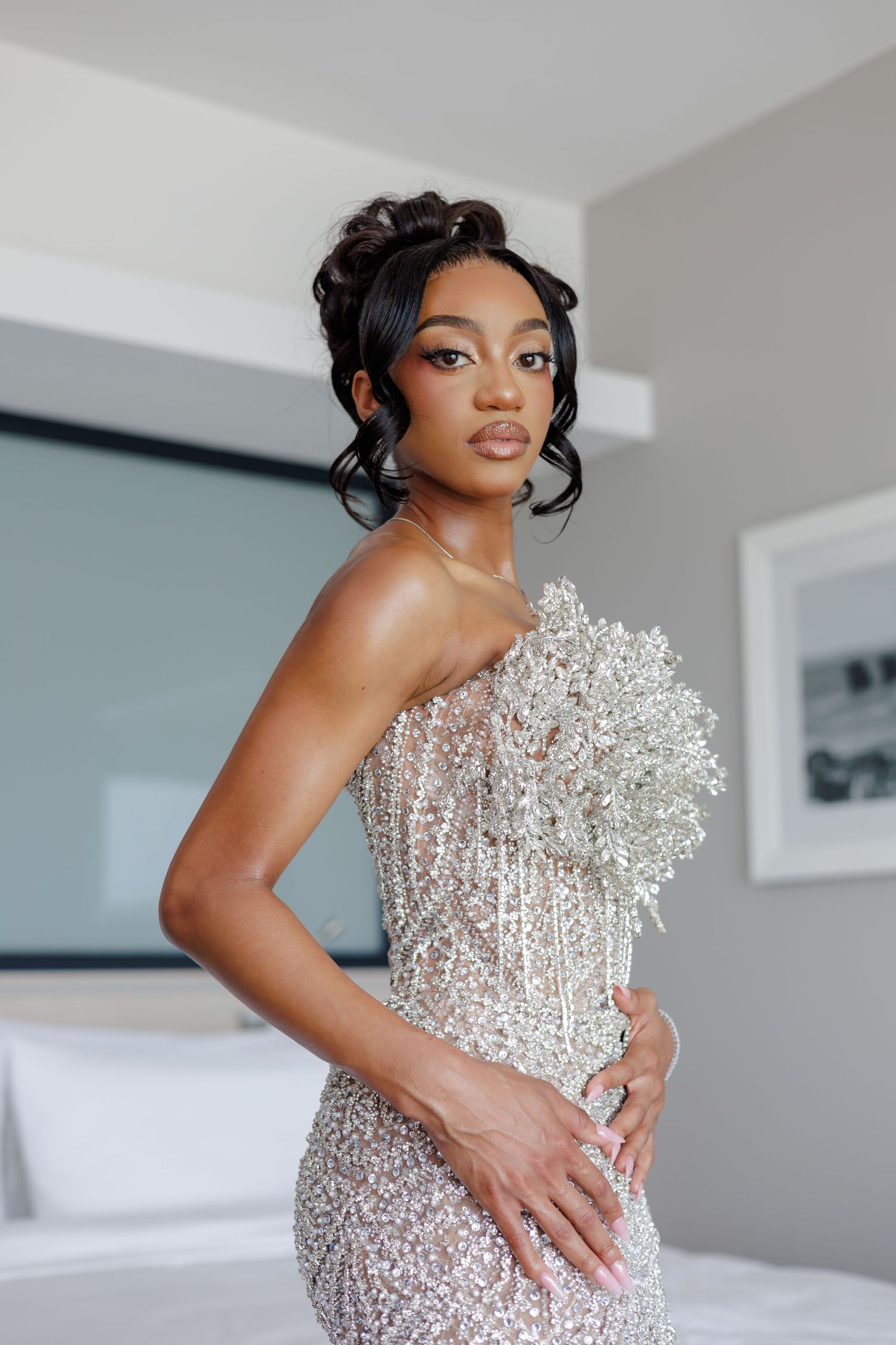 Elegant Black bride in a sparkling sequin gown holding a crystal bouquet, posing in a bright modern room.