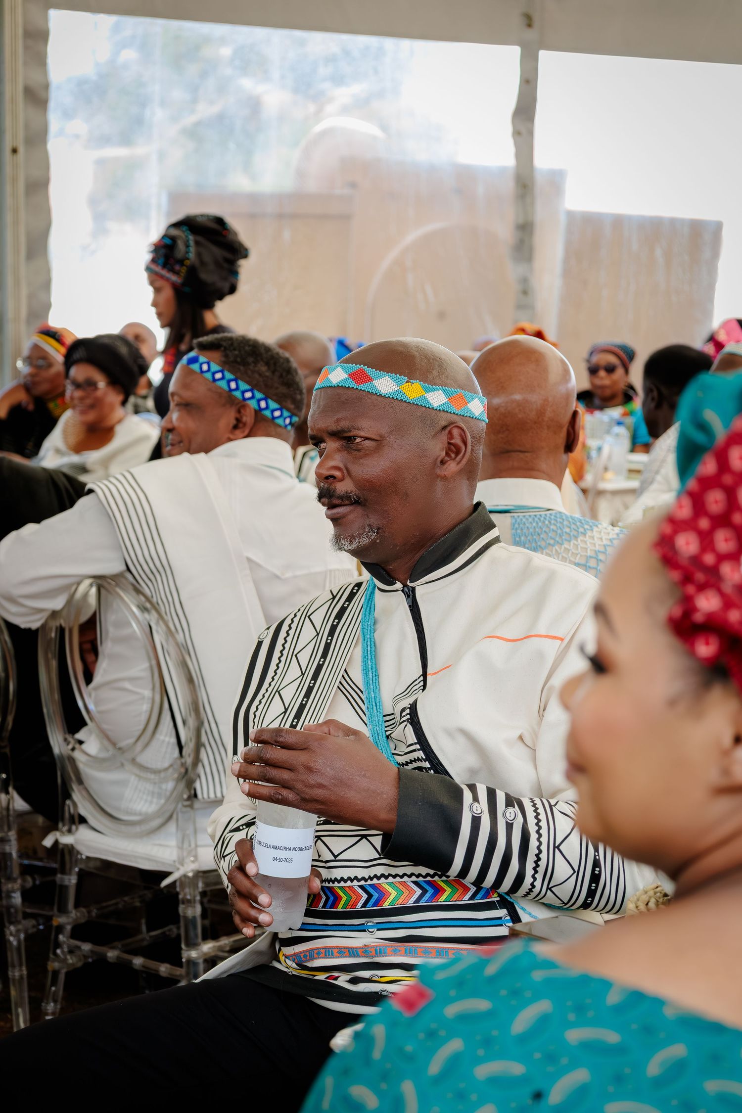 Man in traditional Ndebele attire with beaded headband attending a cultural celebration.
