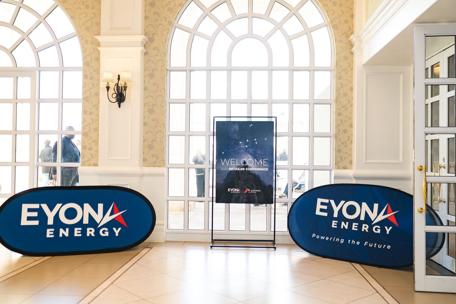 Eyona Energy branded welcome display with oval signs at conference venue entrance.