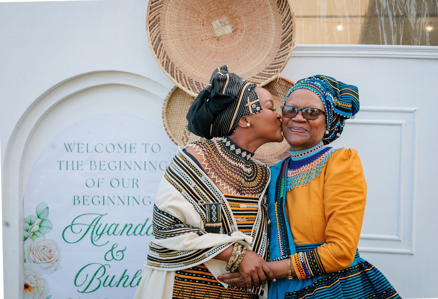 Mother and bride in traditional Xhosa attire share an intimate moment at a Xhosa wedding.