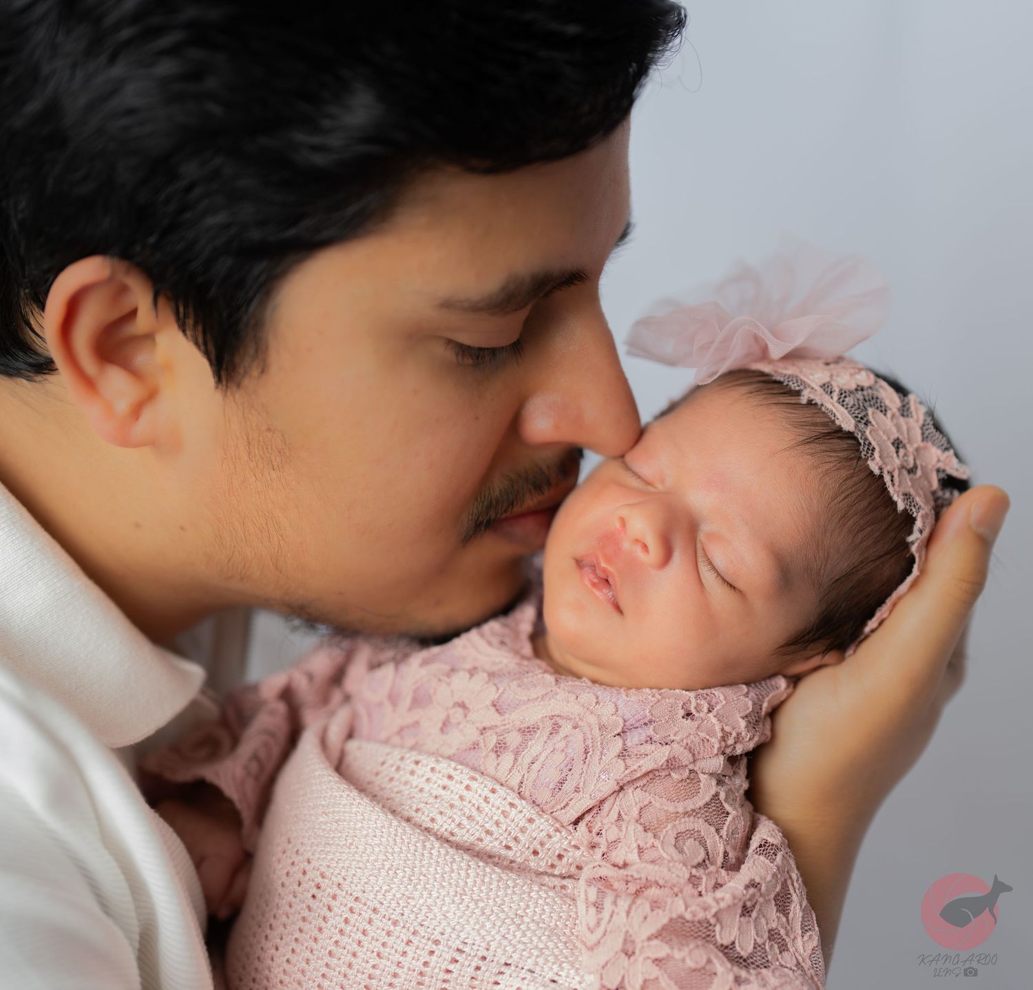 Tender newborn photography session featuring gentle moments and soft pink details.