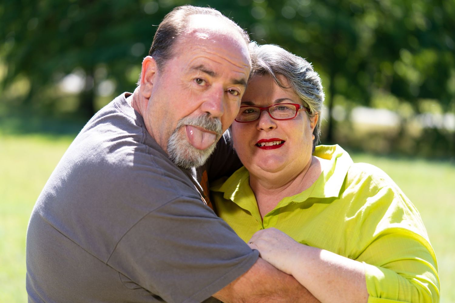 Candid outdoor photos of a couple embracing in bright yellow clothing on a sunny day.