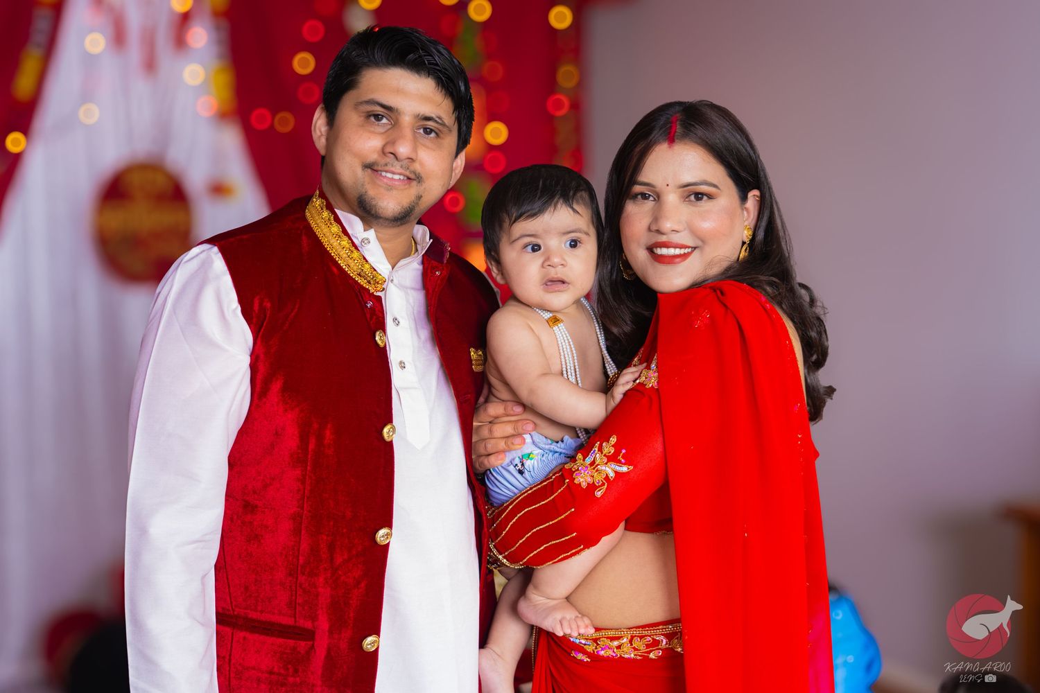 Family celebration photo with traditional red and white cultural attire.