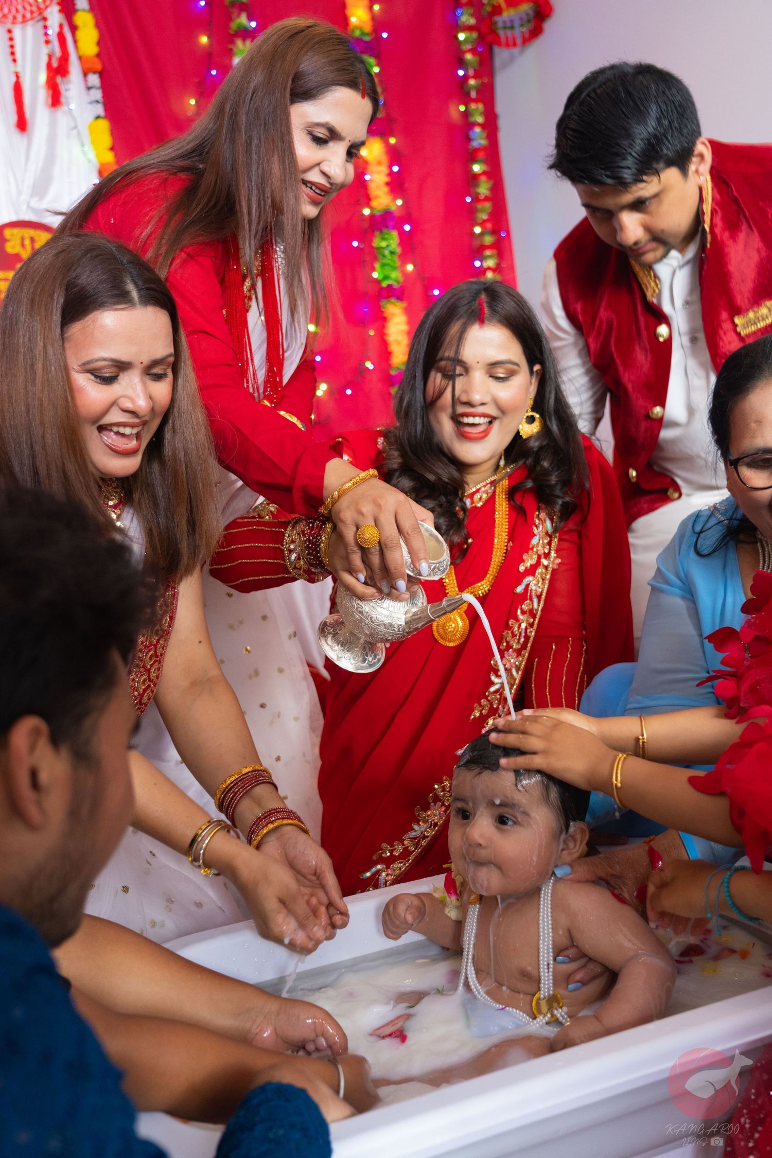 Cultural ceremony with participants gathered around a ritual table with red decorations.