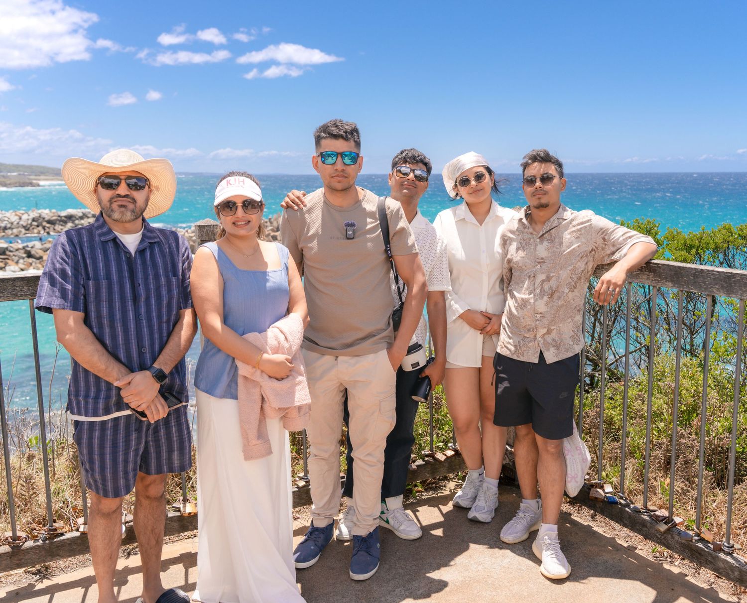 Group photo of people at scenic coastal overlook with ocean view.
