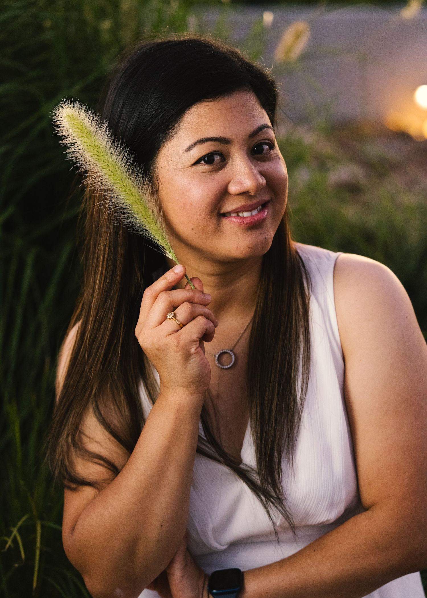 Candid portrait series showing joyful expressions while holding a feathery plant stem.