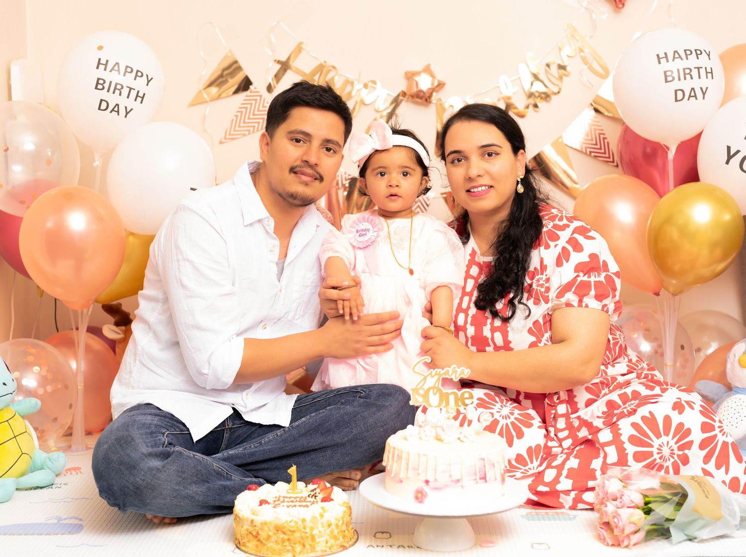 Birthday celebration scene with cake, balloons, and decorations in pink and gold theme.