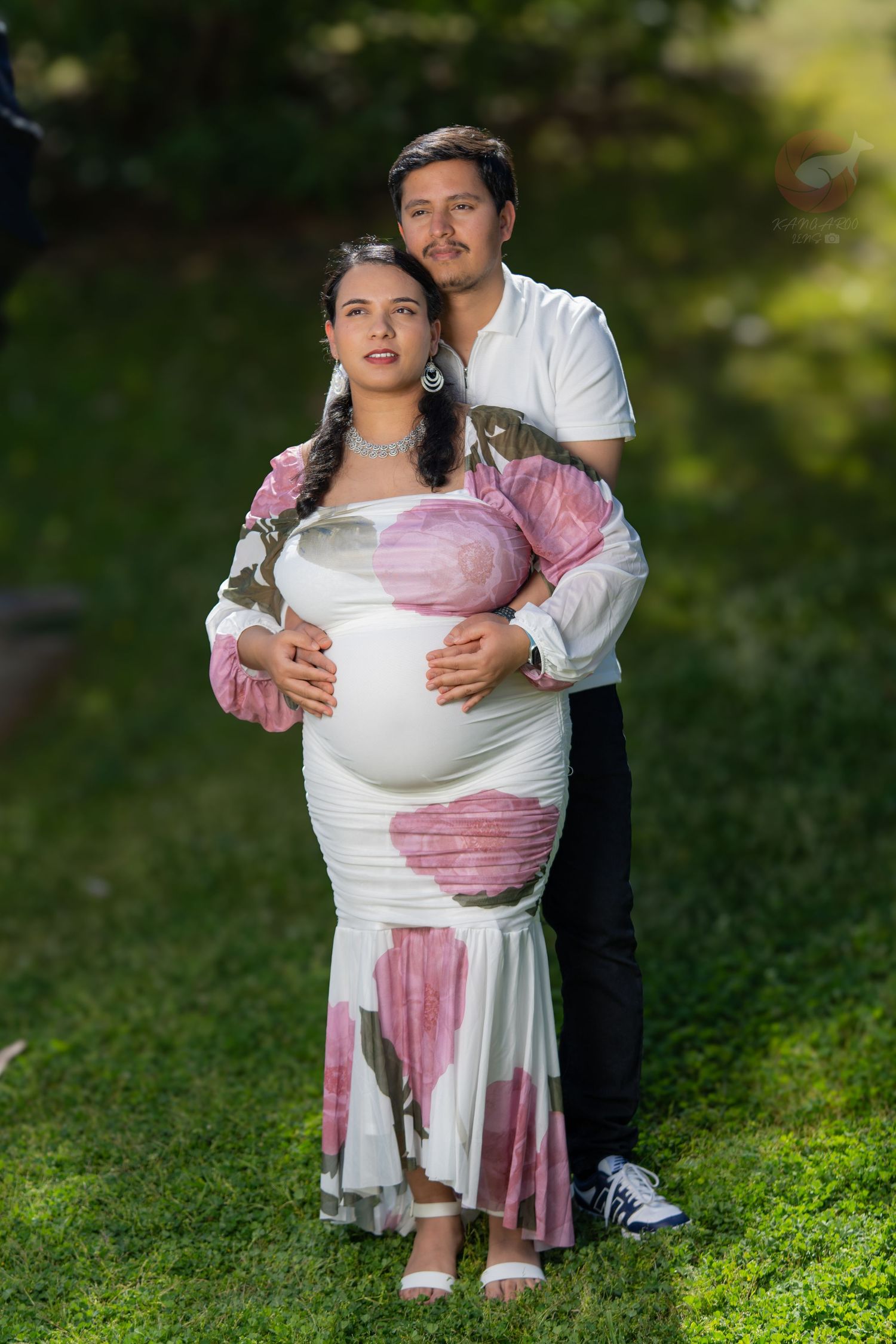 Romantic couple photoshoot in a garden setting with person wearing a pink and white dress.