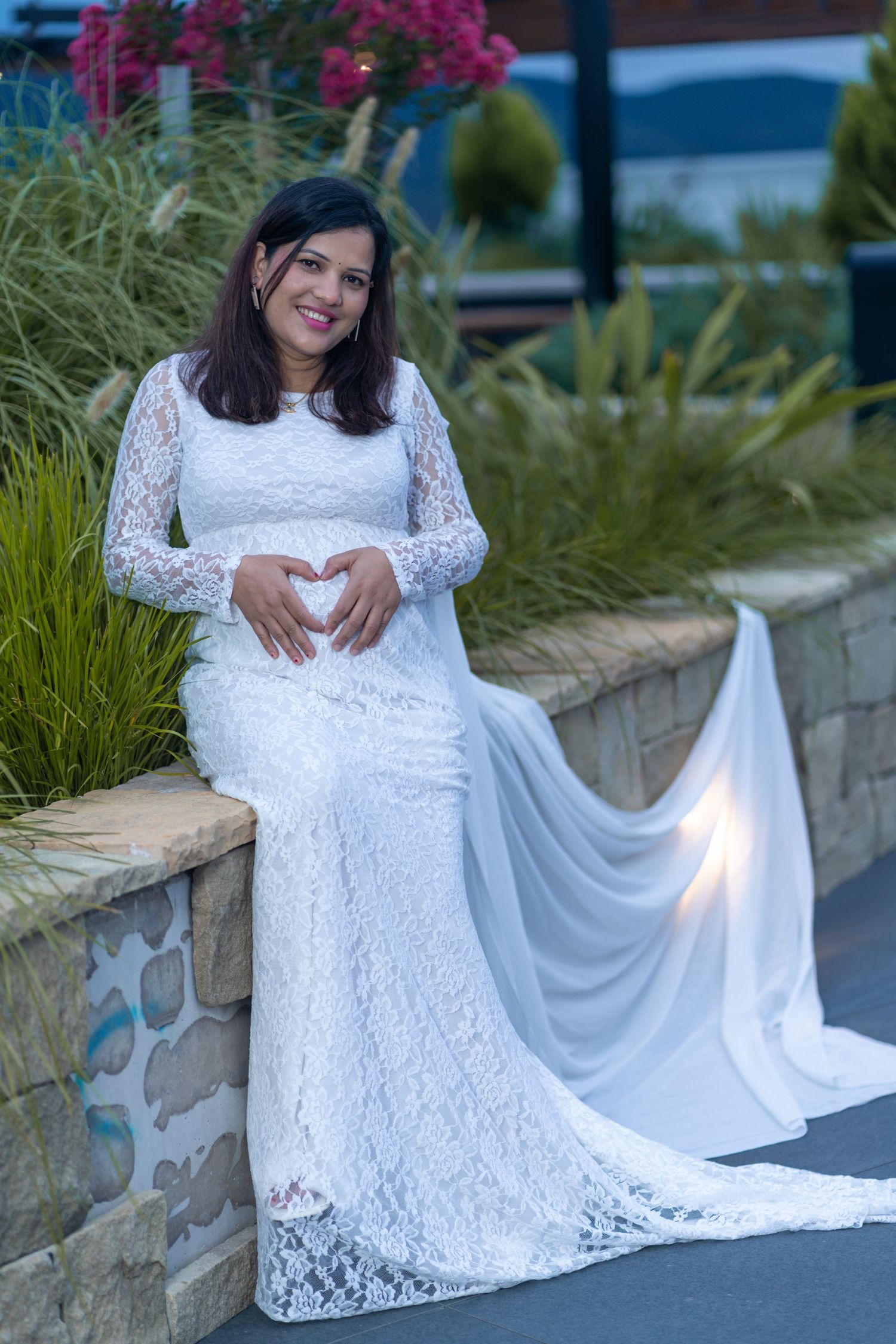 Elegant  portraits in a white lace dress with flowing fabric on stone steps.