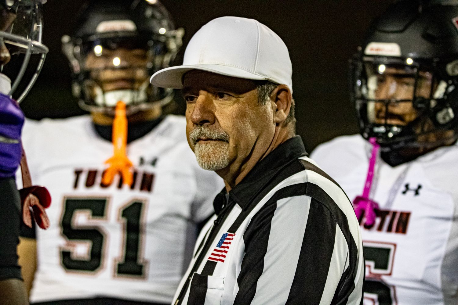 Football official standing on the sideline during a game.