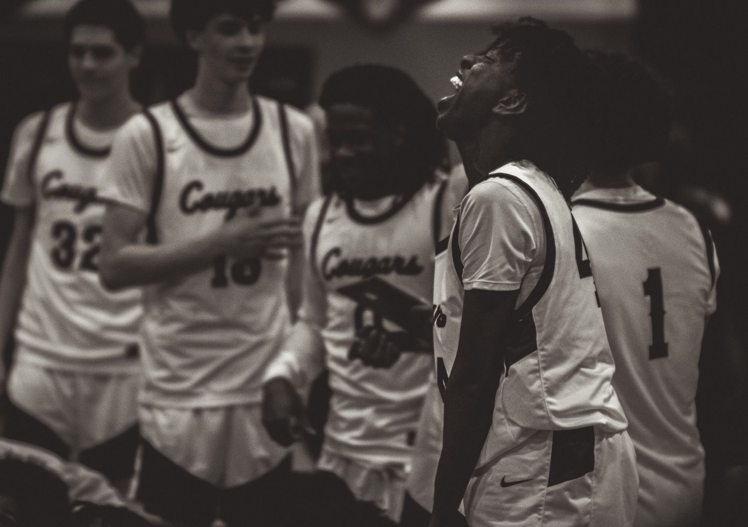 Black-and-white basketball team huddle during a game.