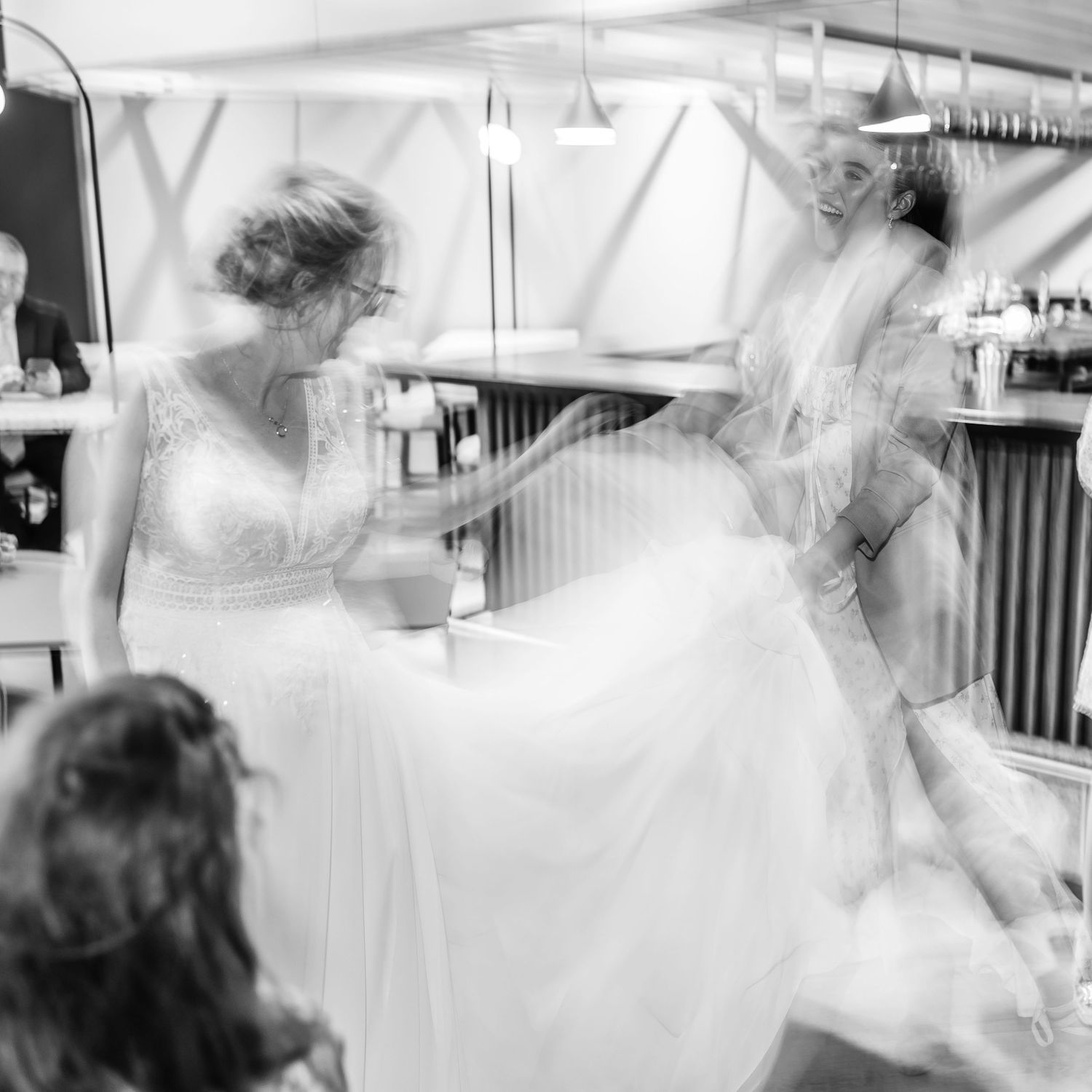 Motion-blurred sequence of wedding celebration dance moves in white dress.