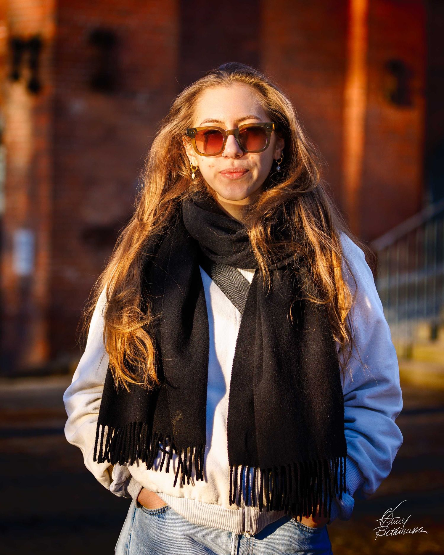 Outdoor portrait sequence showing someone in a black scarf and blue coat in warm evening light.