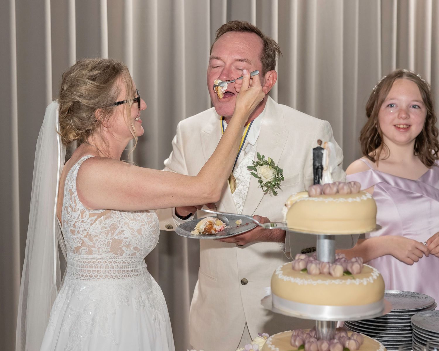 Wedding reception celebration showing festive moments around a decorated cake and table settings.