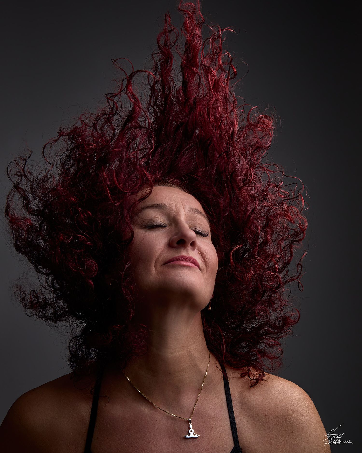 Artistic portraits featuring dramatic red curly hair movement against dark background.