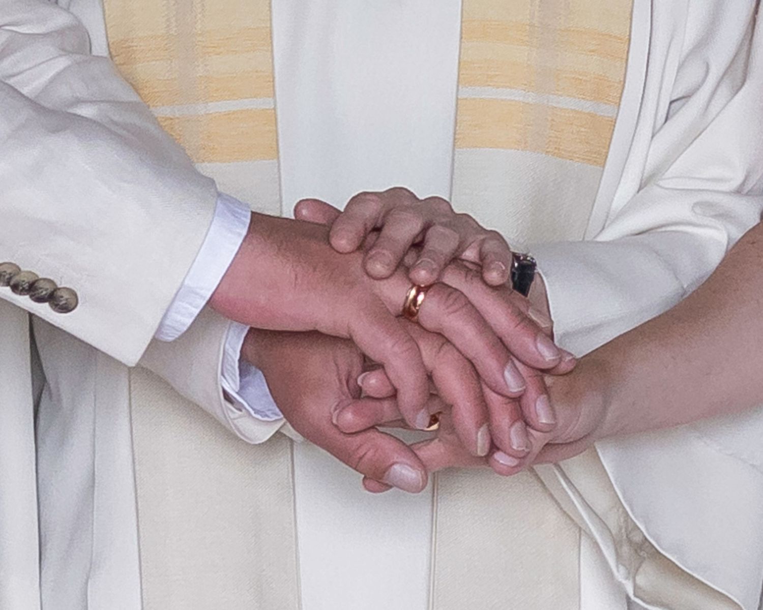A series of close-up shots showing clasped hands against a light-colored background.