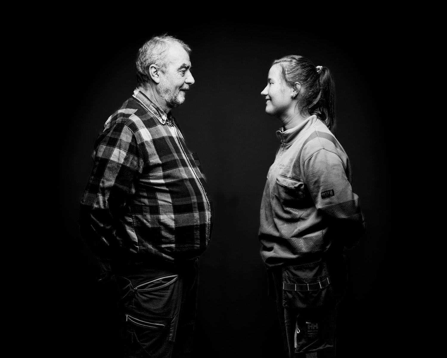 Black and white portrait of two people in conversation wearing casual attire.