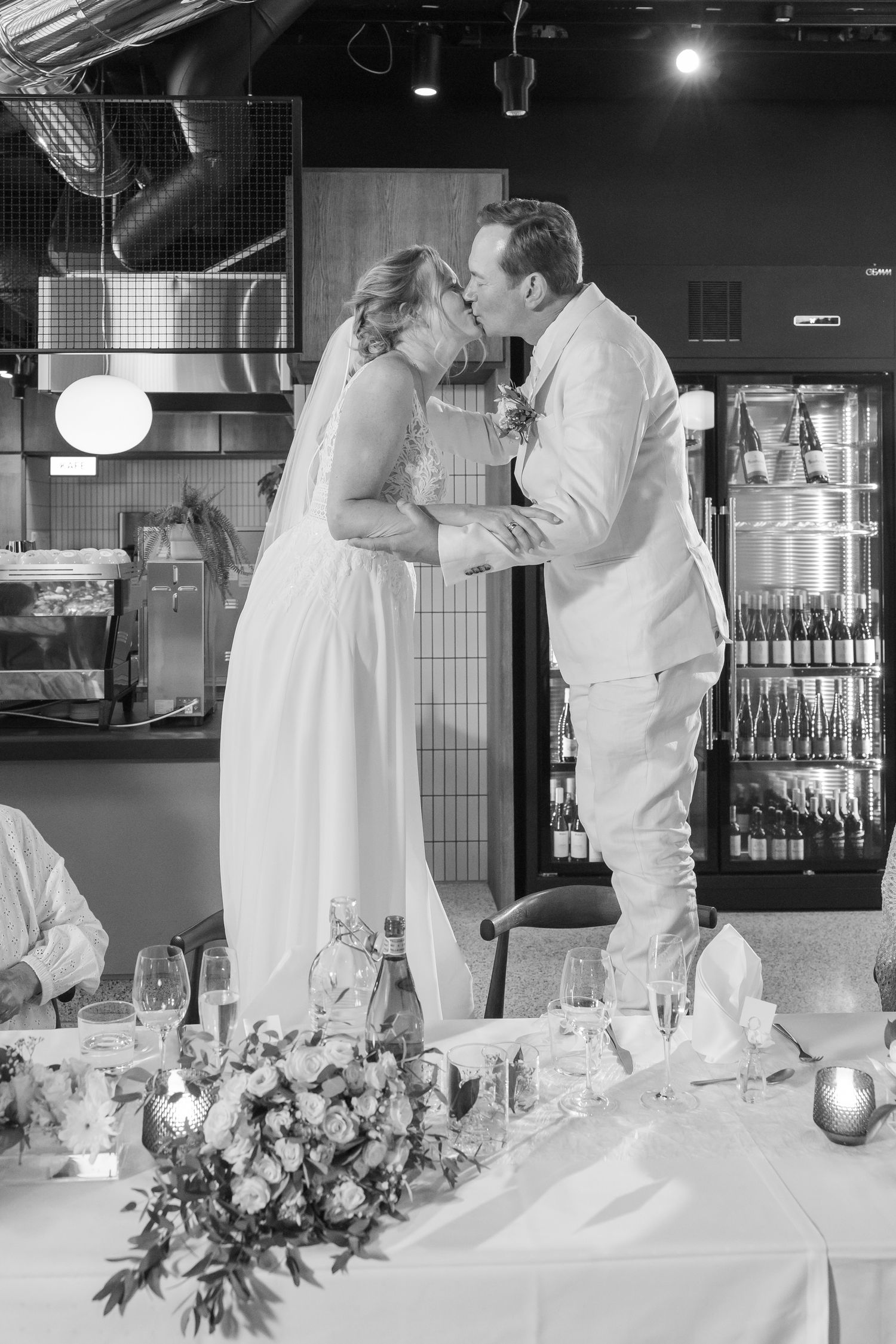 Black and white photos showing a wedding reception dance sequence with people in white attire.