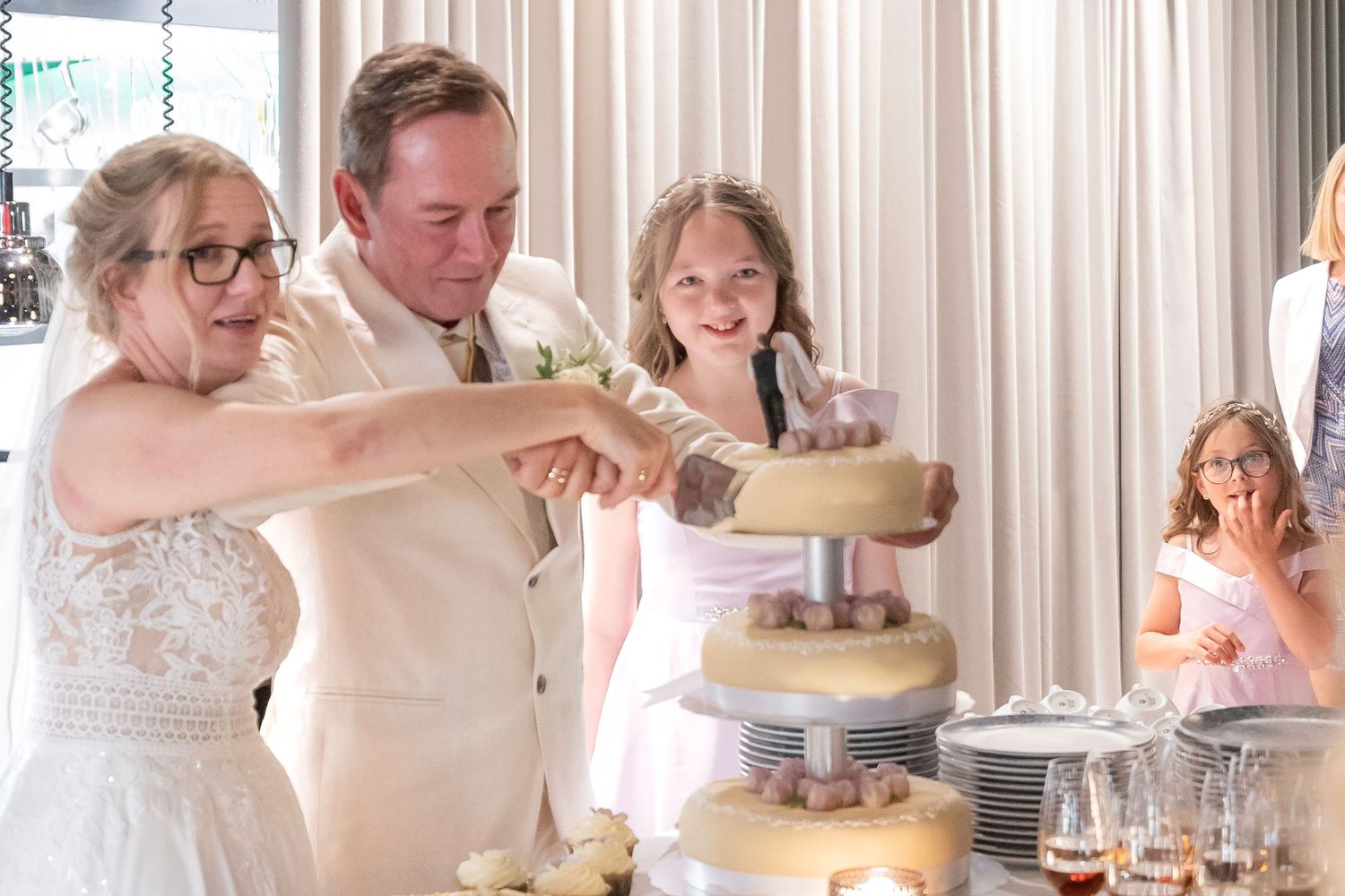 A wedding celebration scene showing cake cutting and champagne toasting moments.