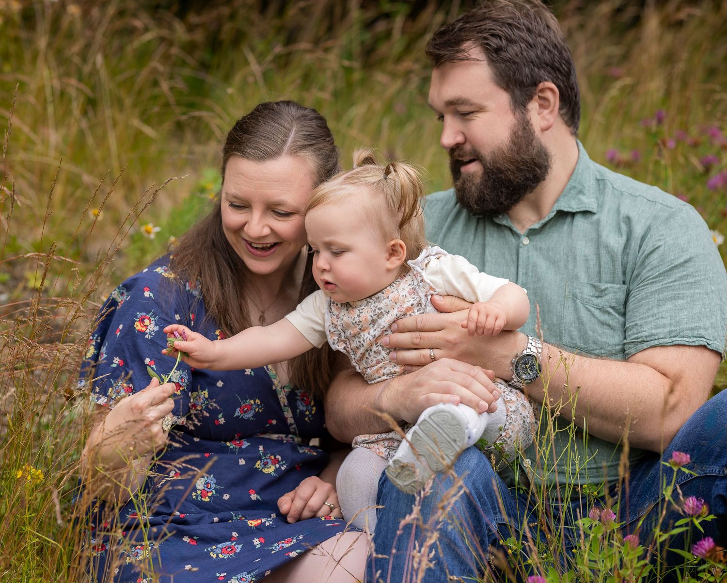 Gledelig familiebilde av mor, far og barn utendørs om sommeren under familiefotografering i Oslo.