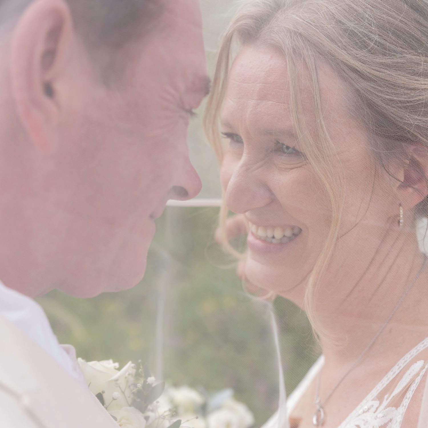 A tender moment captured between a couple on their wedding day in soft natural lighting.