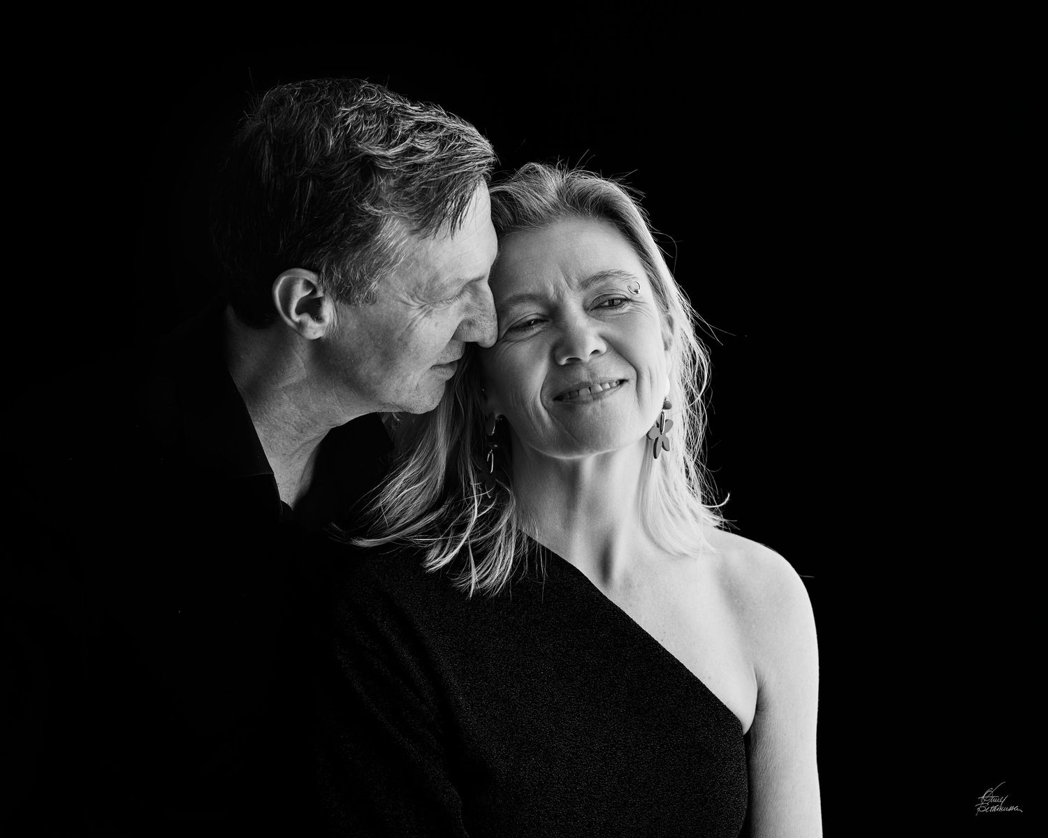 Intimate black and white portrait of couple sharing tender moment.