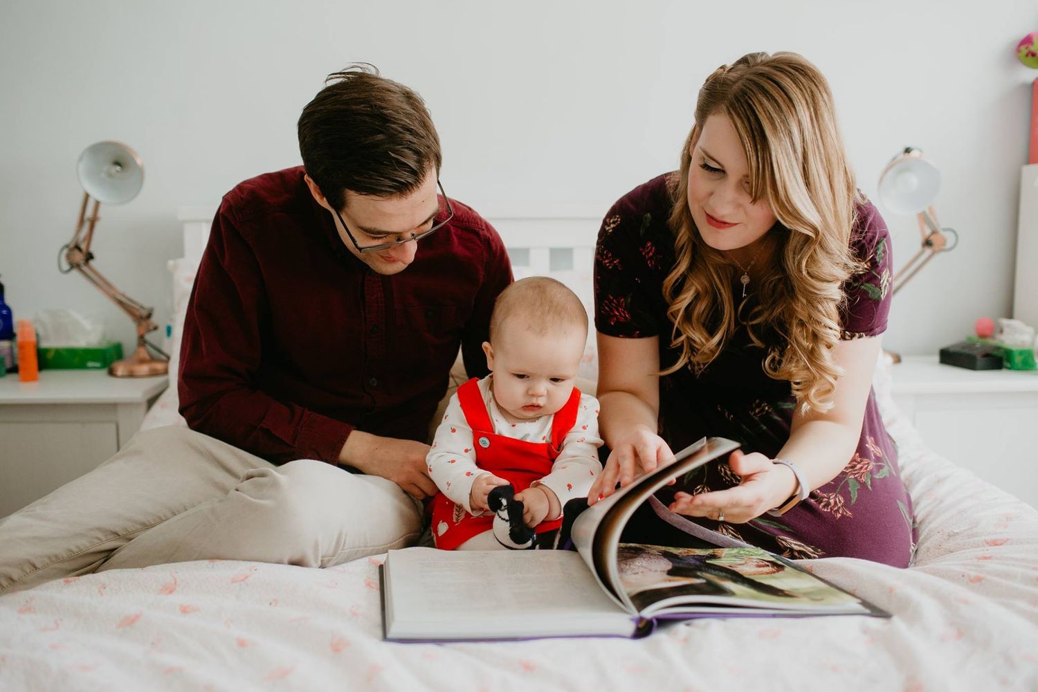 A family spends quality time reading and bonding together in a bright bedroom.