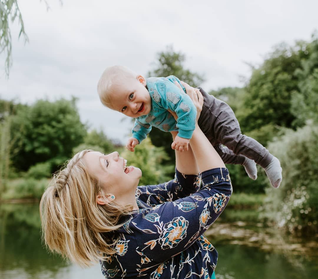 Mother holding child during outdoor family photography near Saffron Walden