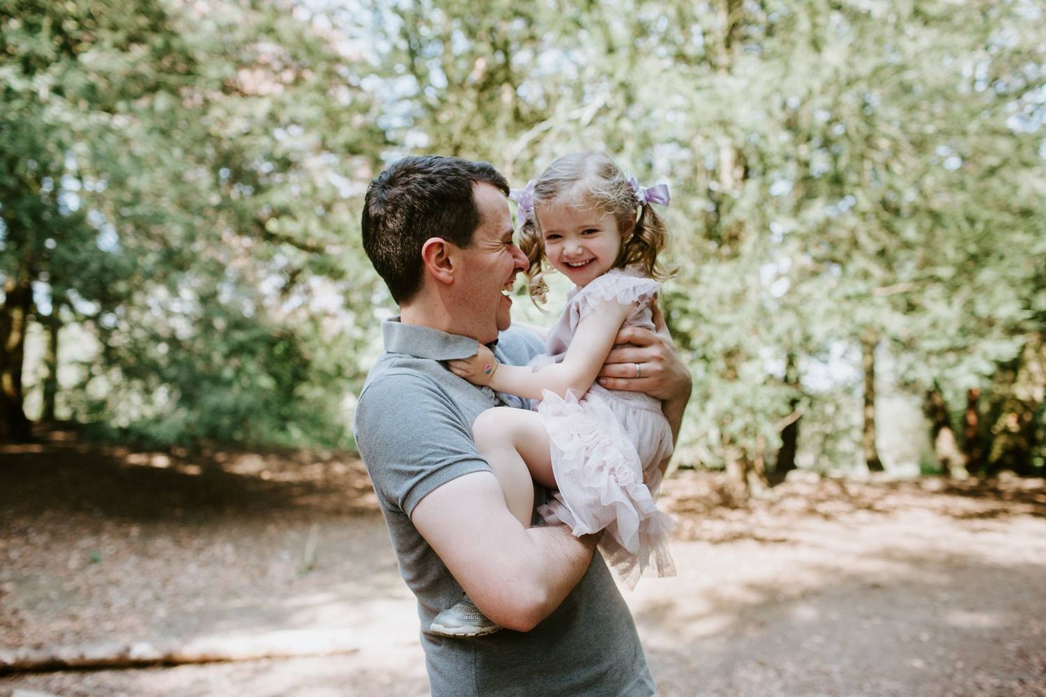Sweet outdoor moment between parent and child in dappled sunlight.
