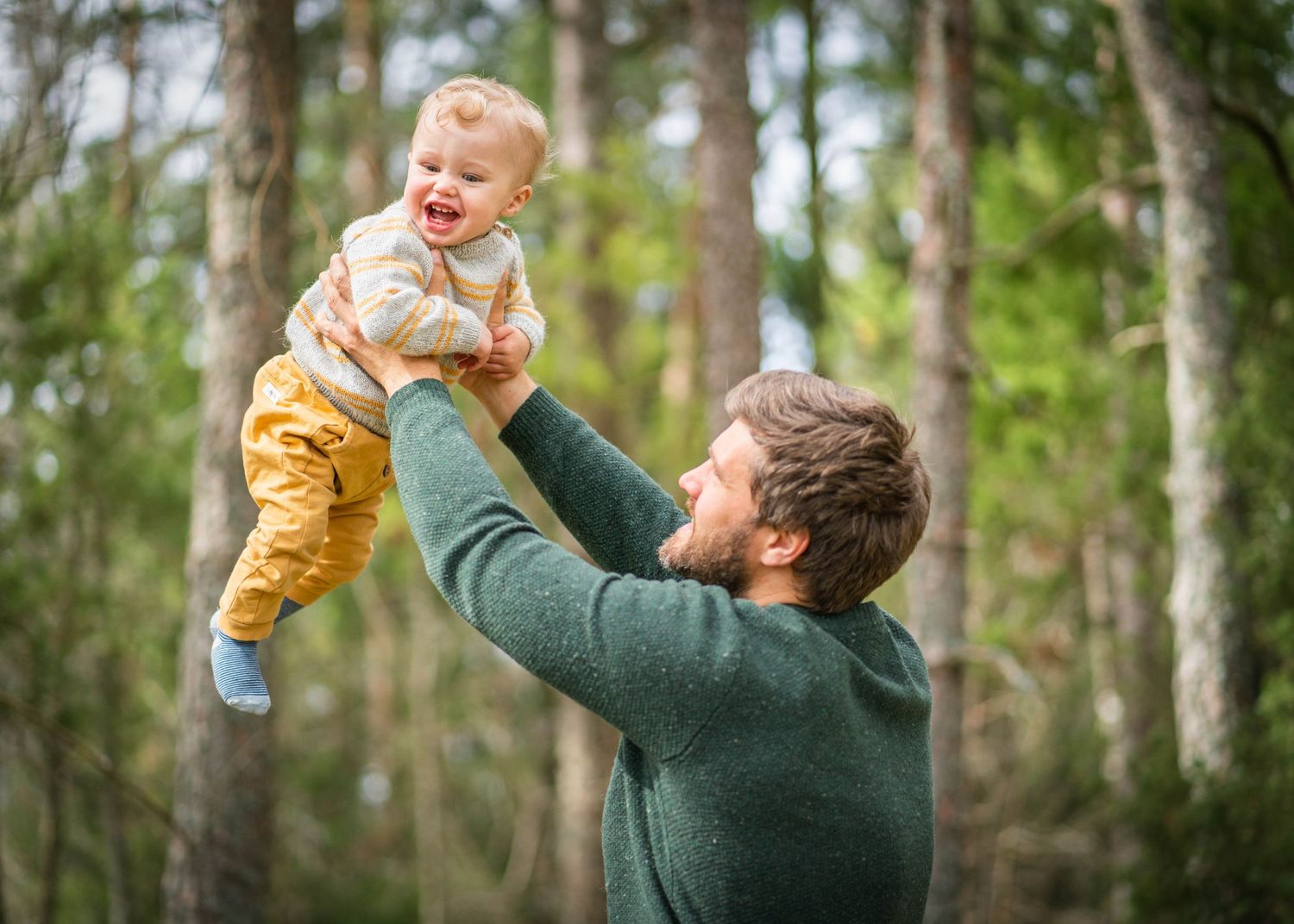 Joyful playtime moment in forest setting with spring greenery.