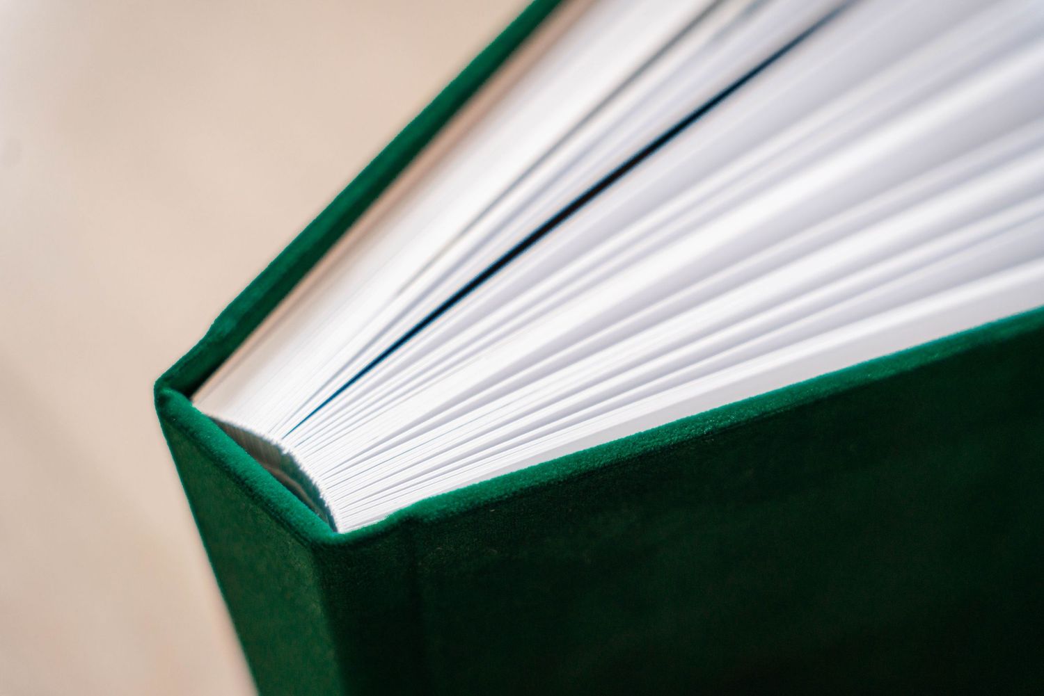 Professional photo album with emerald green cover and crisp white pages.