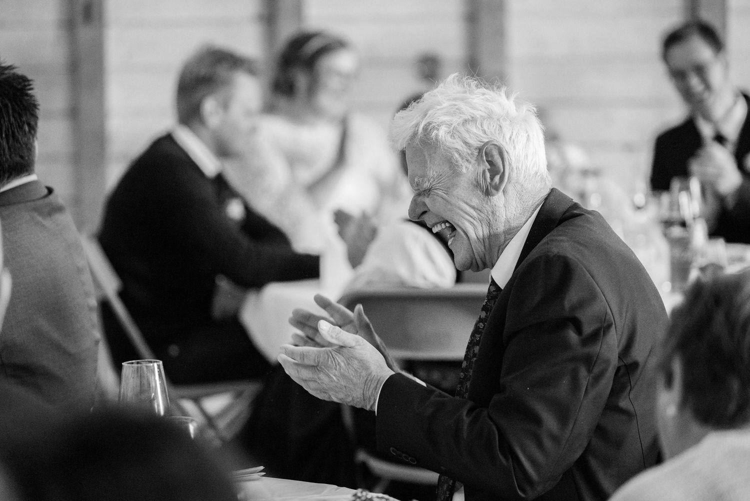 Elderly couple dancing together at a social gathering while other seniors watch in the background.